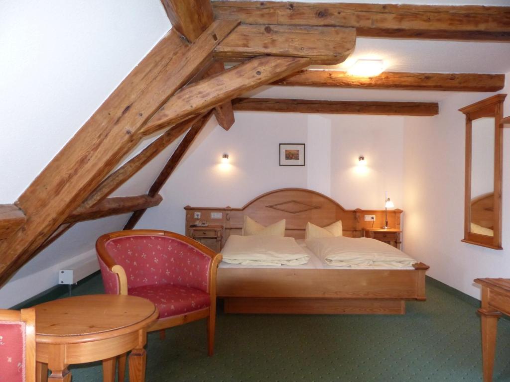 ein Schlafzimmer mit einem Bett und einem Tisch und Stühlen in der Unterkunft Hotel zum Brauhaus in Quedlinburg