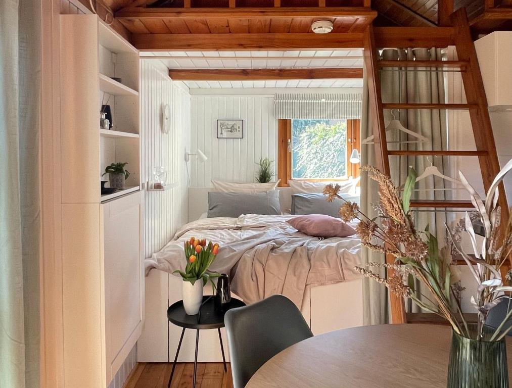 ein kleines Schlafzimmer mit einem Bett und einem Tisch in der Unterkunft Tiny House mit Garten in See-Nähe in Tauche