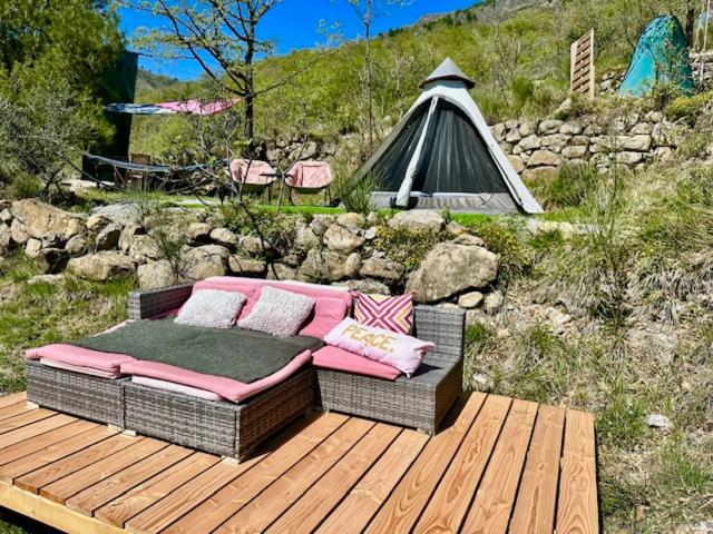 - un canapé installé sur une terrasse en bois avec une tente dans l'établissement Tipi sous les étoiles service petit déjeuner et dîner, à Lucéram