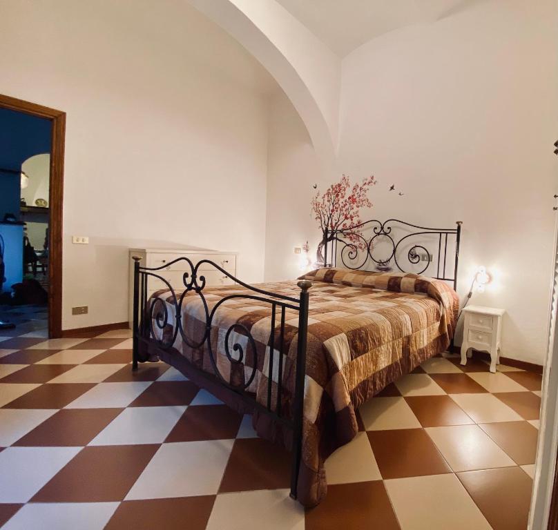 a bedroom with a bed and a checkered floor at La sosta del viandante in Sinalunga