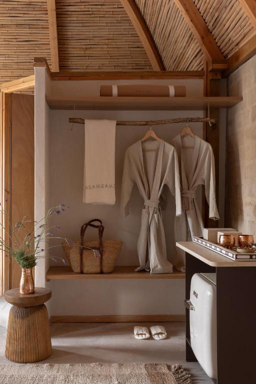 a dressing room with coats and shoes on shelves at Moa Living in Ẕofar