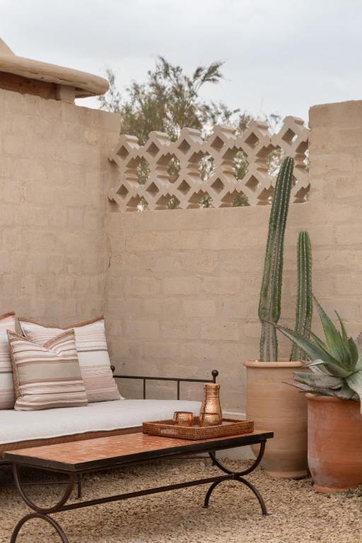 a patio with a couch and a table and cactus at Moa Living in Ẕofar
