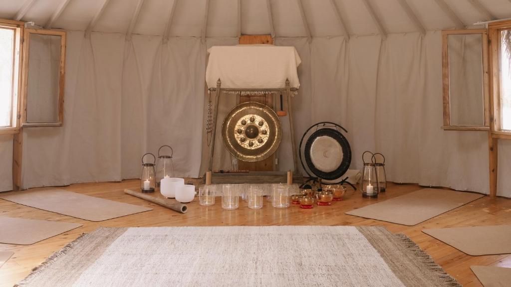 a room with a white tent with mats and a mirror at Moa Living in Ẕofar