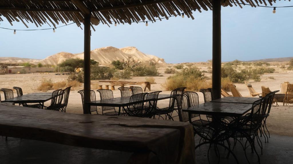 a group of tables and chairs with a view of the desert at Moa Living in Ẕofar