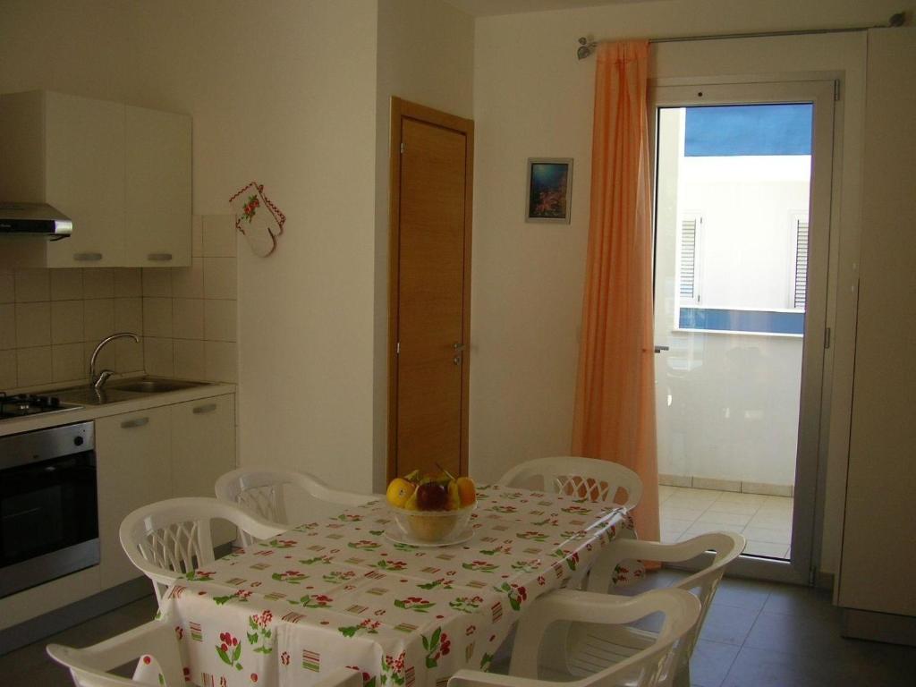 una cocina con una mesa con un bol de fruta. en Ferienwohnung für 6 Personen ca 40 qm in Conchiglie-Alto Lido, Apulien Provinz Lecce, en Baia Di Gallipoli