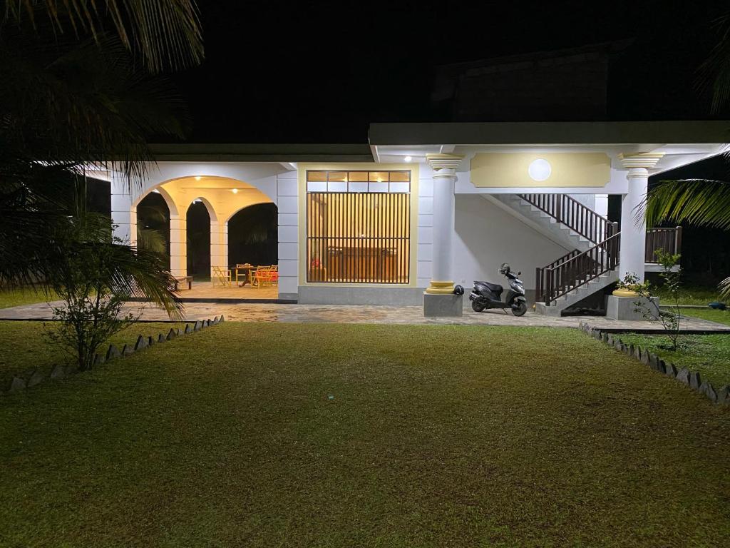 a house with a motorcycle parked in front of it at night at Villa La more in Unawatuna