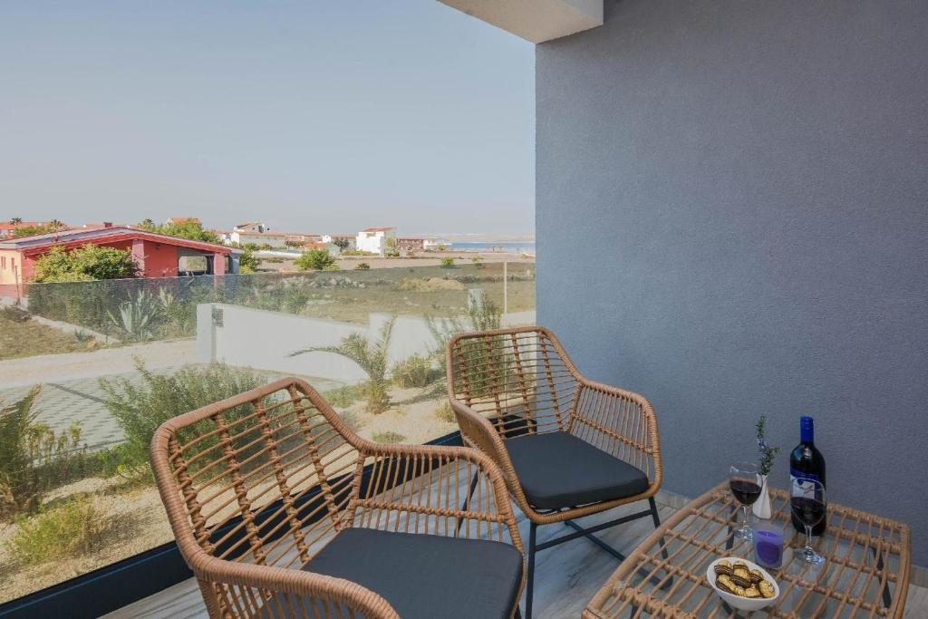 een balkon met 2 stoelen en een tafel met wijnflessen bij Ferienwohnung für 4 Personen ca 75 qm in Vir, Dalmatien Inseln vor Zadar - b53410 in Vir