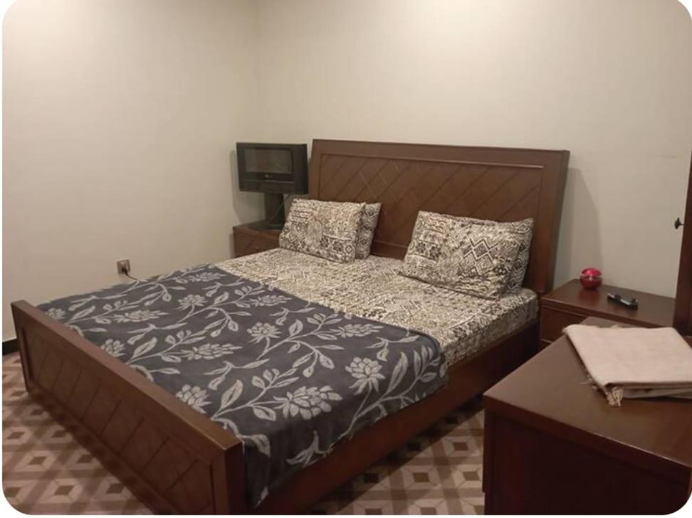 een slaapkamer met een bed en een tv. bij House 81-C in Islamabad