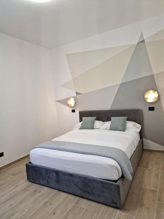 - une chambre avec un grand lit et un mur géométrique dans l'établissement ARI'S HOME, à La Spezia
