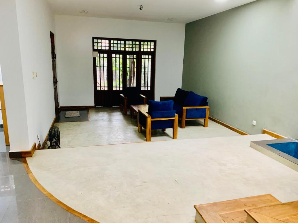 sala de estar con sillas azules y mesa en House for Rent -Near Colombo, en Gampaha