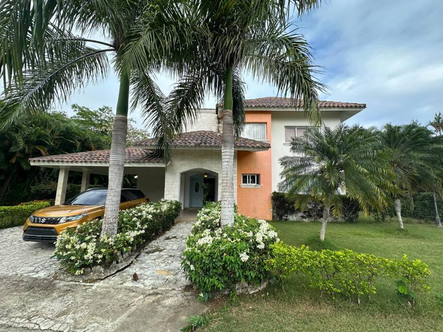 a car parked in front of a house with palm trees at Luxury Village at Juan Dolio. in Juan Dolio