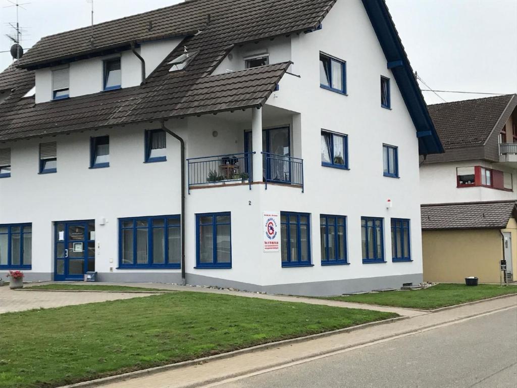 Edificio blanco con ventanas azules y balcón en Ferienwohnung für 4 Personen ca 76 qm in Schutterzell, Schwarzwald Ortenau, en Neuried