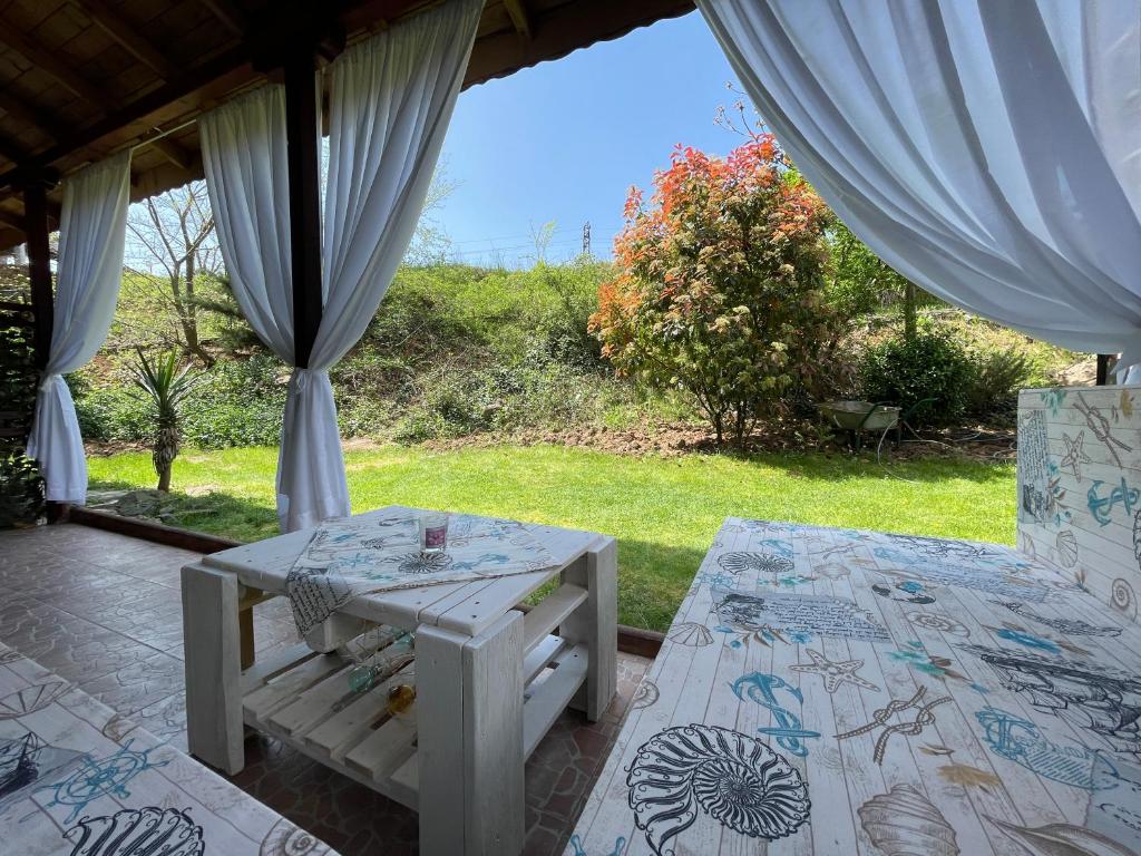 una mesa y un banco en una habitación con vistas a un campo en Sea Salt Suite- Sozopol, en Sozopol