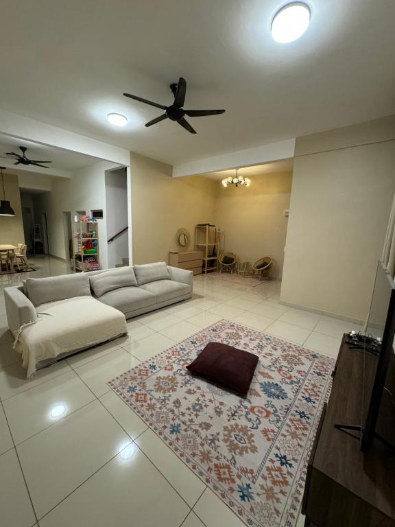 un soggiorno con divano e ventilatore a soffitto di DAHLIA Homestay a Jitra