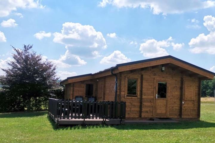 una piccola cabina in legno con recinzione in un campo di Domek the luxe a Šluknov