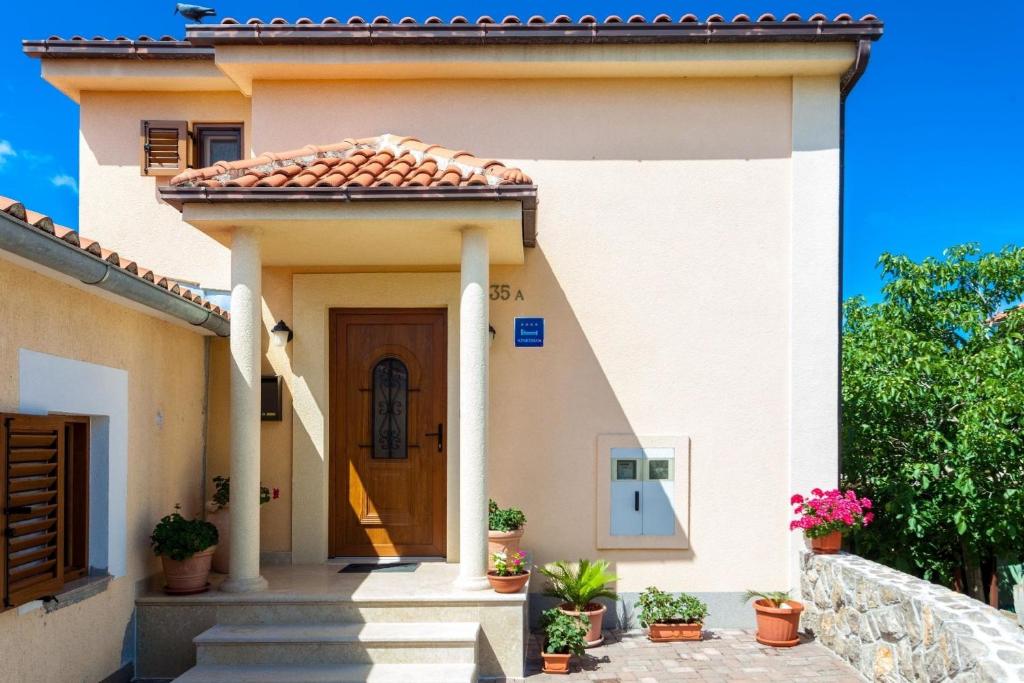 a house with a door and potted plants at In der Nähe des Meeres, schöne und moderne Wohnung in Porat