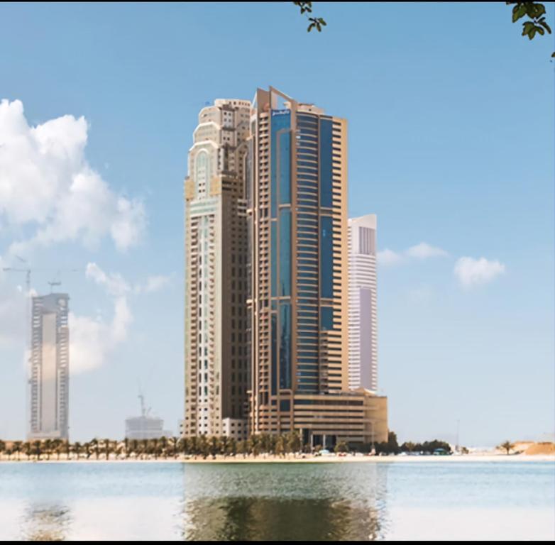 a rendering of a tall building in the middle of the water at Cityscape Retreat Apartment in Sharjah