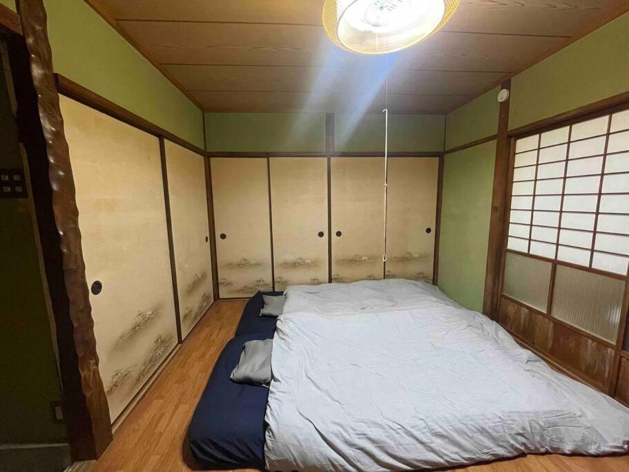 新宫市シングウノイエ【貸切】熊野古道　速玉大社　那智の滝　神倉神社　マグロ　和歌山ラーメン　的一间光线充足的客房内的一张床位