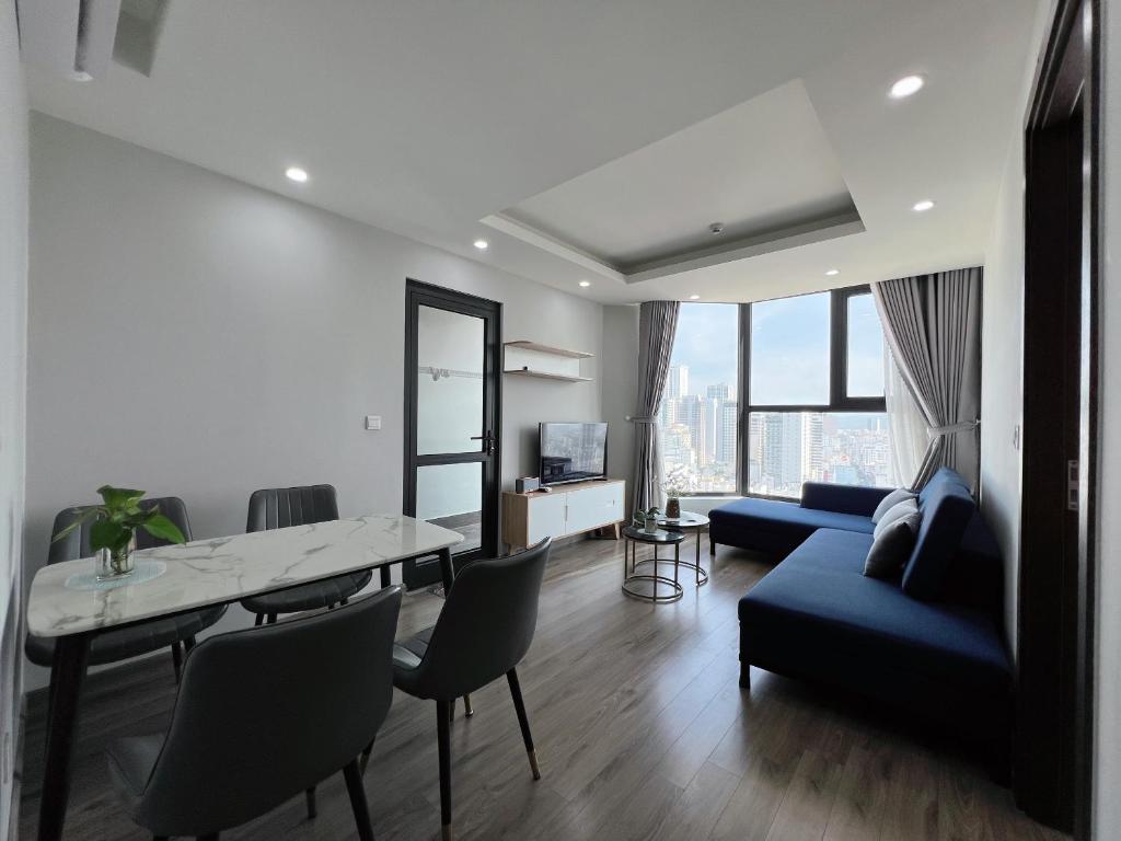 Una sala de estar con una mesa y un sofá azul. en Sea Horizon Apartment, en Nha Trang