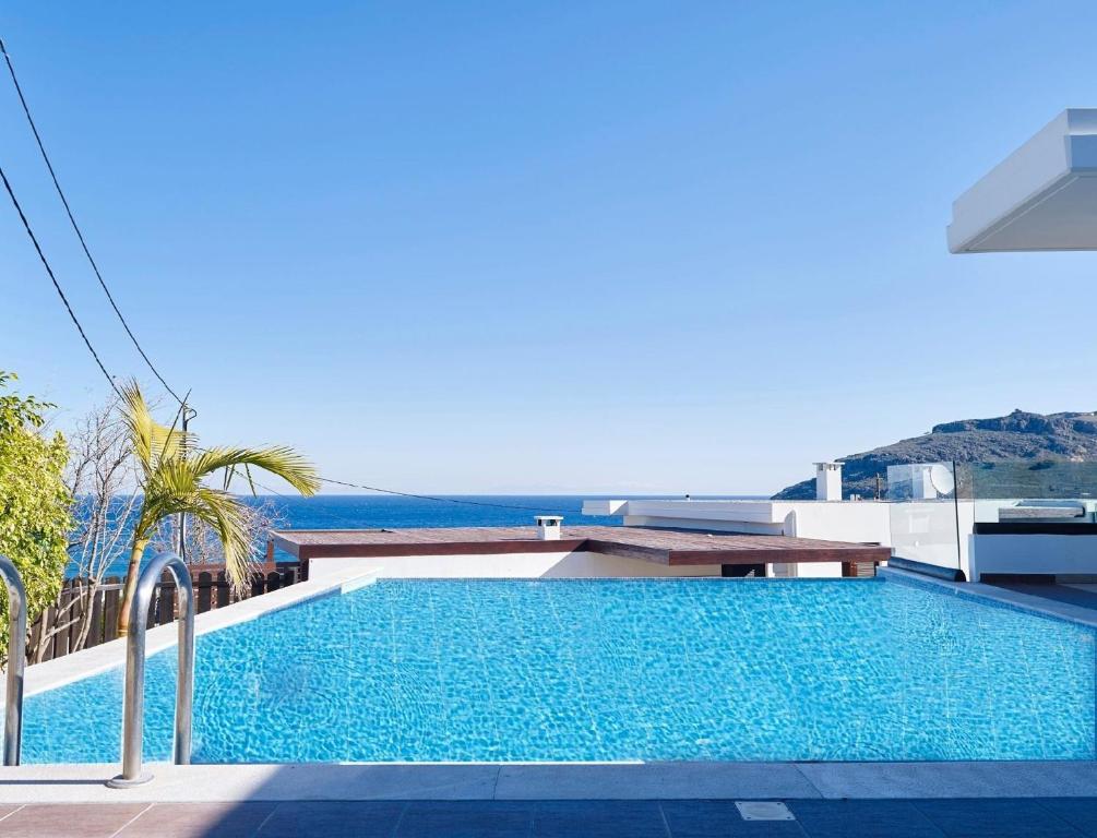 a swimming pool on top of a building with the ocean in the background at Ferienhaus in Vlycha Beach mit privatem Pool und herrlicher Aussicht in Líndos