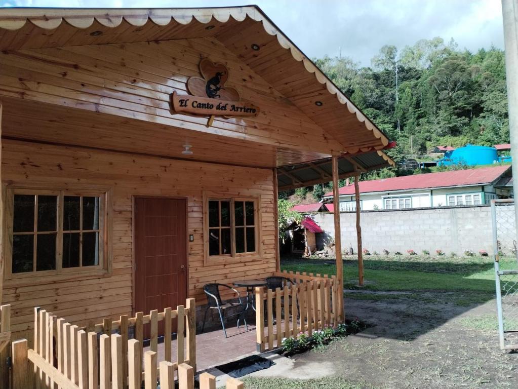 une cabane en bois avec une table et une clôture dans l'établissement Cabaña El canto del Arriero, à Oxapampa