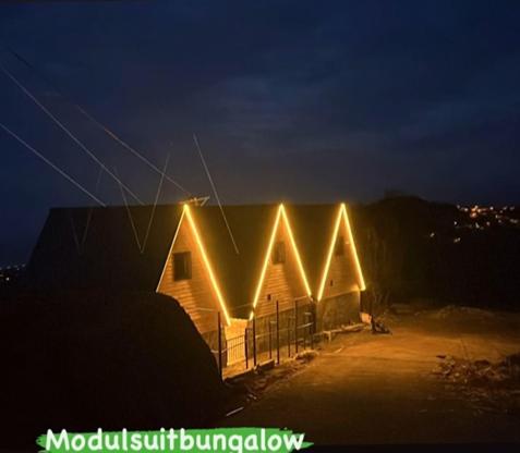 a building with lights on the side of it at night at Modul Suit & Bungalov in Rize