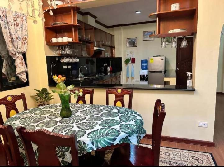 a dining room table with a vase of flowers on it at Villa Ceferina in Tagbilaran City