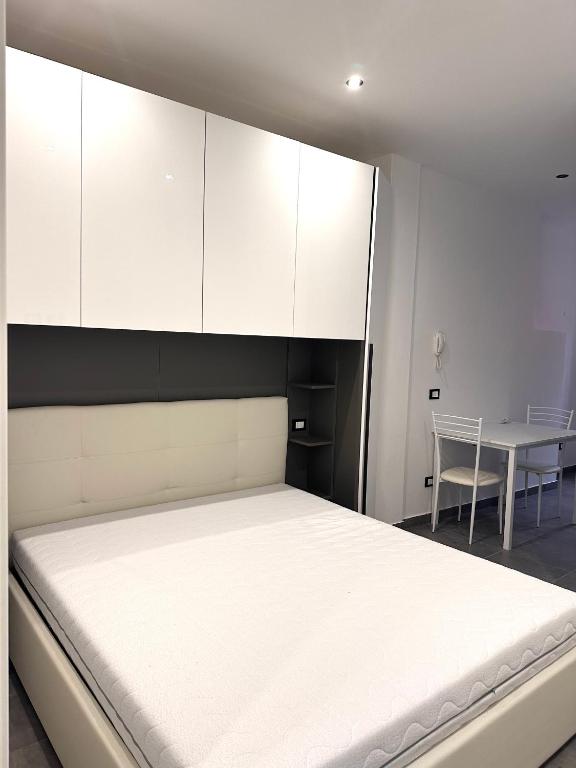 1 dormitorio con 1 cama con armarios blancos y mesa en Appartamentino Via Trotti, en Cremona