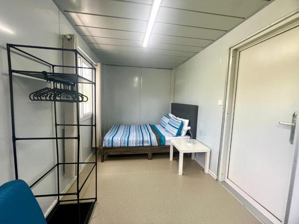 ein kleines Zimmer mit einem Bett und einem Regal in der Unterkunft Grace Container homes in Cedar Grove