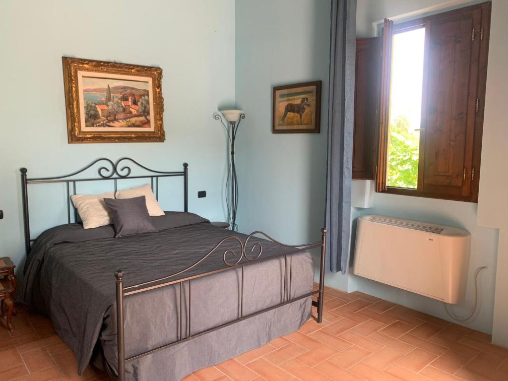 ein Schlafzimmer mit einem Bett, einer Lampe und einem Fenster in der Unterkunft Guest House Torre Guelfa in Figline Valdarno