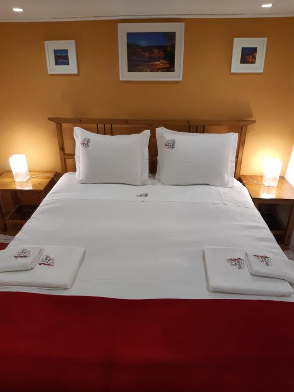 1 cama blanca grande con 2 toallas blancas. en Casa da Avó - Barroca en Barroca