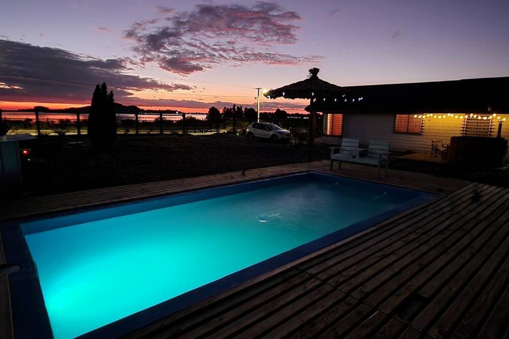 una piscina con puesta de sol en el fondo en Cabaña descanso naturaleza, en Colbún
