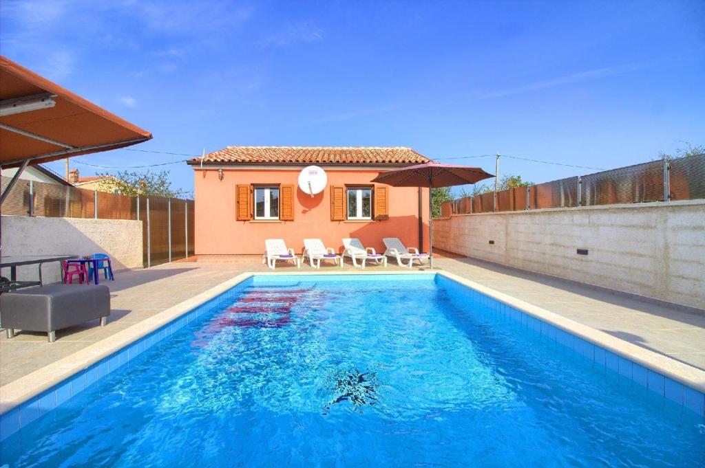 a swimming pool in front of a house at Ferienhaus mit Privatpool für 5 Personen ca 80 qm in Loborika, Istrien Südküste von Istrien in Loborika