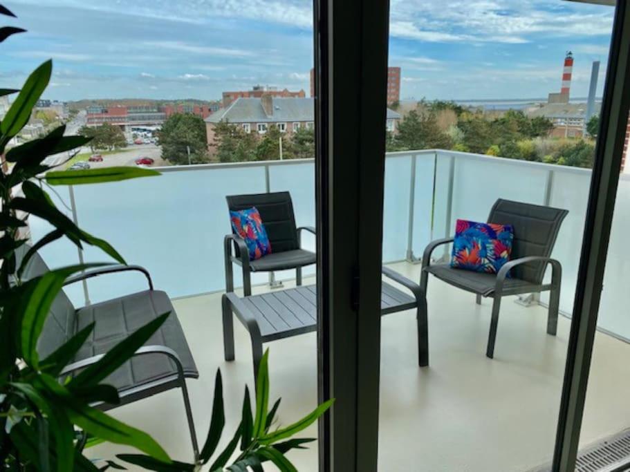 two chairs on a balcony with a view of a city at Bel appartement avec vue sur la Baie d&#39;Authie in Berck-sur-Mer