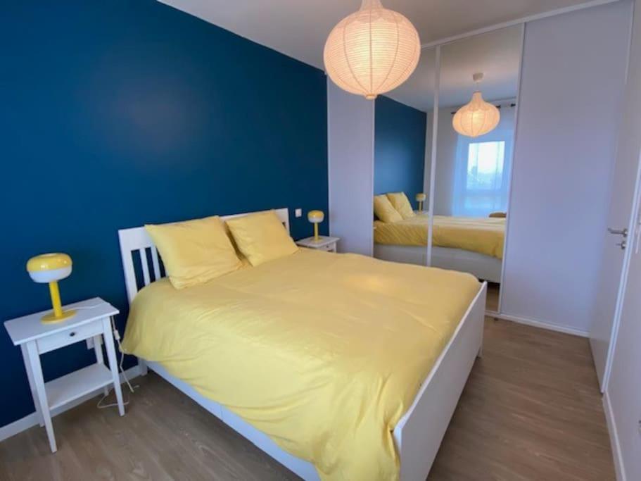 a bedroom with a yellow bed and a blue wall at Bel appartement avec vue sur la Baie d&#39;Authie in Berck-sur-Mer