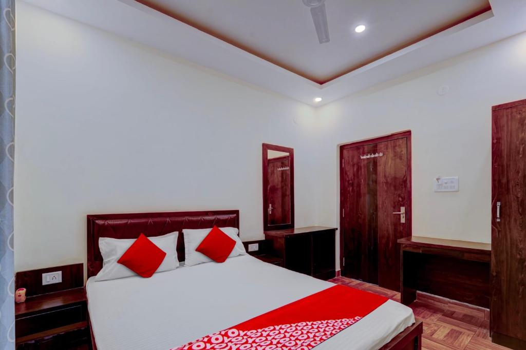een slaapkamer met een bed met rode kussens bij Flagship Hotel Days Inn in Rānchī