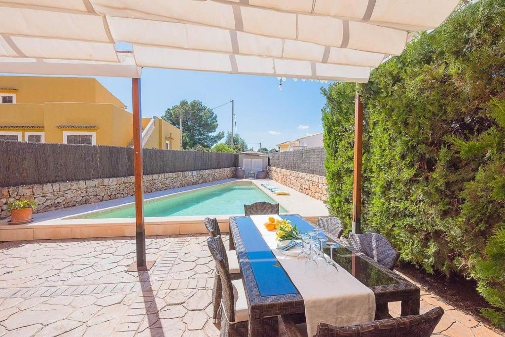 uma mesa com um guarda-sol ao lado de uma piscina em Ferienhaus mit Privatpool für 6 Personen ca 120 qm in Sa Rapita, Mallorca Südküste von Mallorca em Sa Ràpita