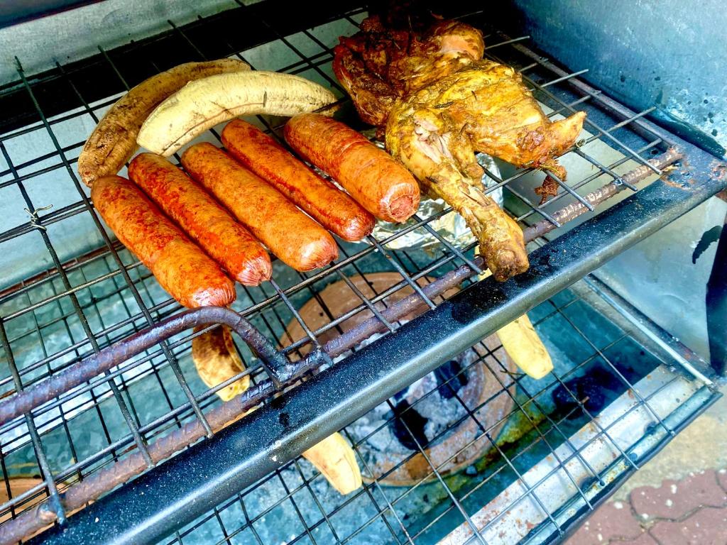 een rek met hotdogs en een banaan en vlees bij A private self contained room in a home away from home in Dar es Salaam
