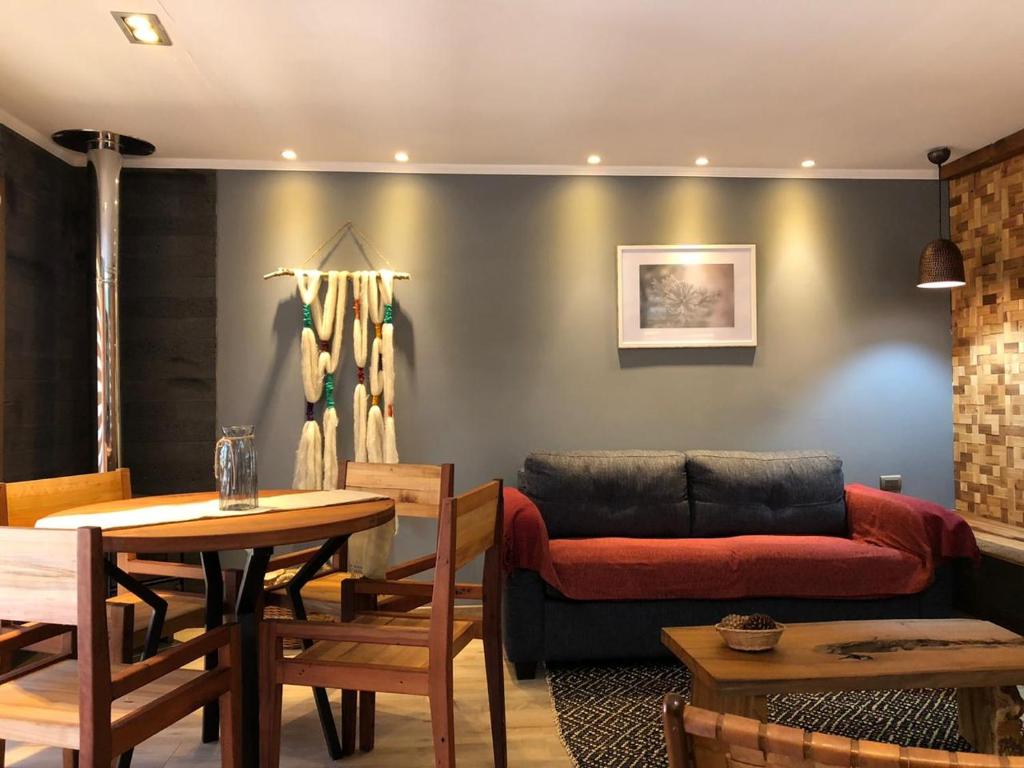 uma sala de estar com um sofá e uma mesa em Lodge Crux em Pichilemu