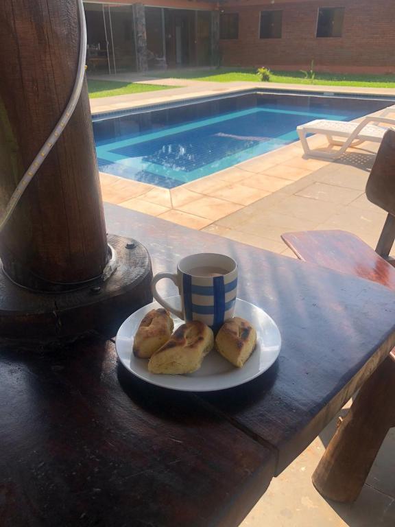een bord koekjes en een kopje koffie op een tafel bij Quinta Dulce Morada in Capiatá