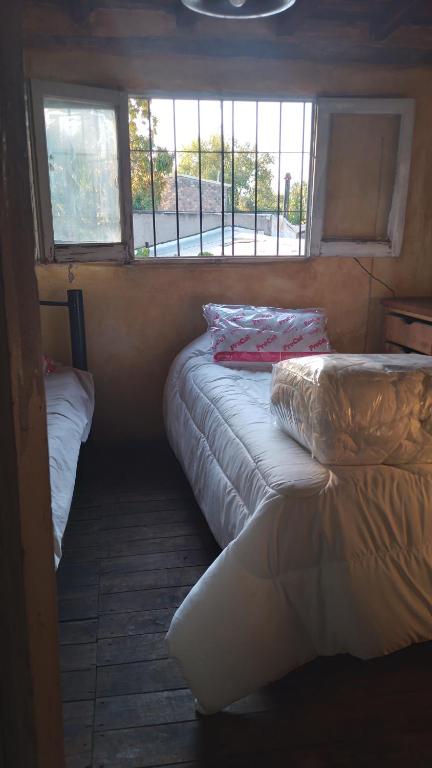 Habitación pequeña con 2 camas y ventana en HOSTEL CHACRAS en Luján de Cuyo
