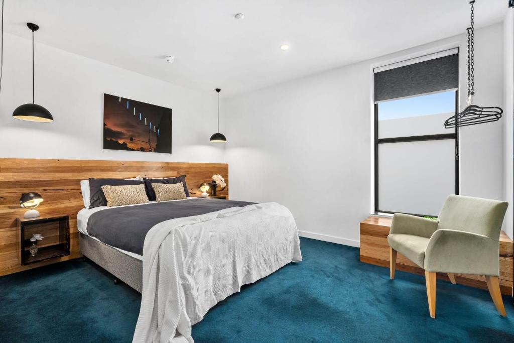 um quarto com uma cama e uma cadeira em The Electric Hotel em Geelong