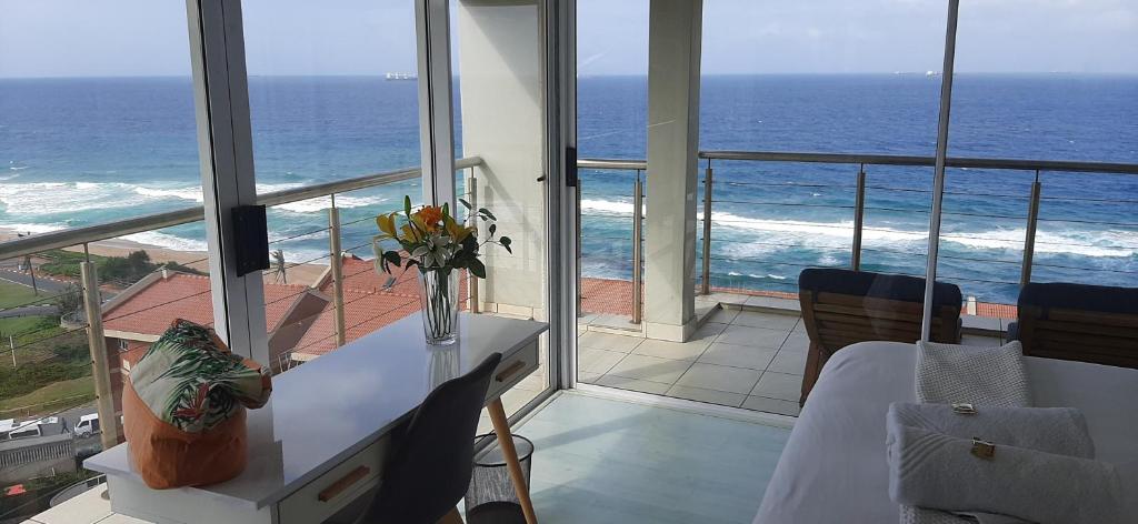 a room with a table and a view of the ocean at 511 Umdloti Resort BREAKERS VIEW TO DIE FOR in Umdloti