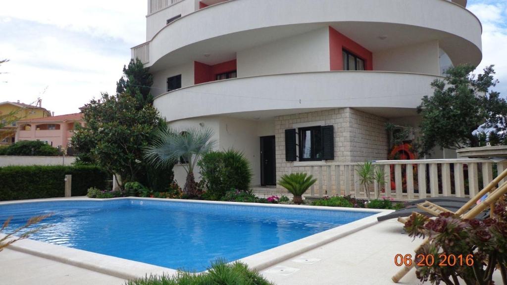 un edificio con piscina frente a una casa en Ferienwohnung für 2 Personen 2 Kinder ca 60 qm in Ližnjan, Istrien Südküste von Istrien - b53757, en Ližnjan