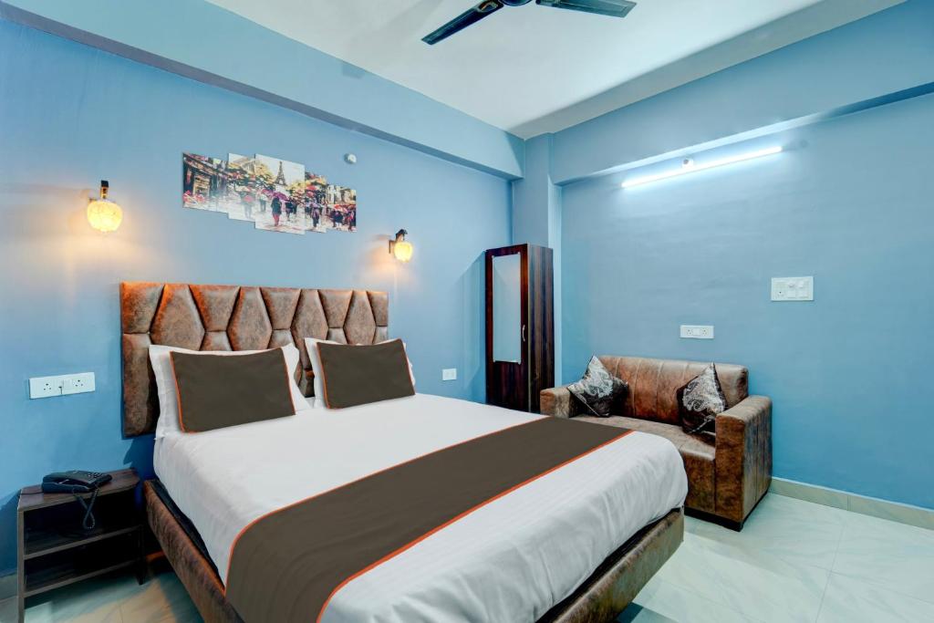 a bedroom with a large bed and a chair at Collection O Hotel Dream Villa in Patna