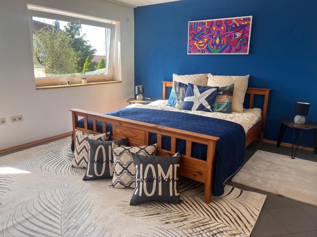1 dormitorio con 1 cama con pared azul en Gemütliche, sonnendurchflutete Ferienwohnung in Bodenseenähe am Säntisblick, en Herdwangen-Schönach