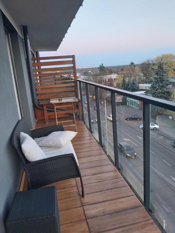 a balcony with two chairs and a table and a street at Przy Parku in Wyszków