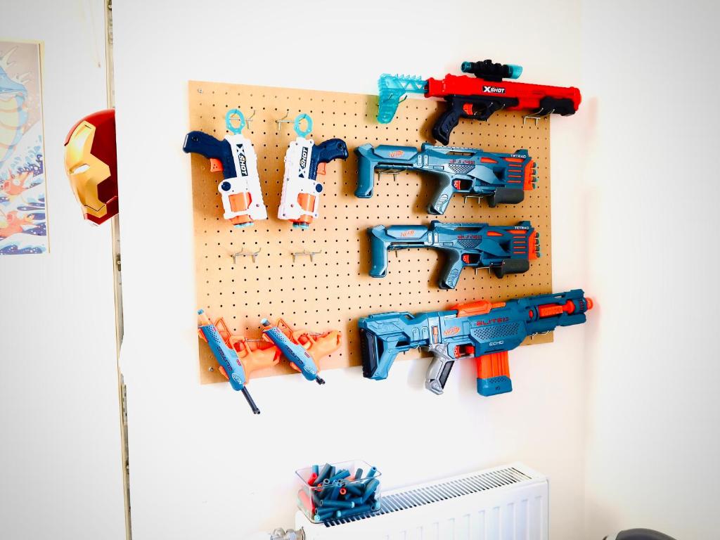a group of toy guns hanging on a wall at Bourg Palette for 10 - Parking - Netflix - Wifi - Nerf in Bussy-Saint-Georges
