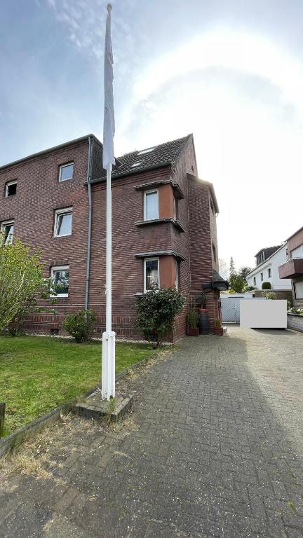 a flag pole in front of a brick building at Gästehaus-Schild in Dormagen