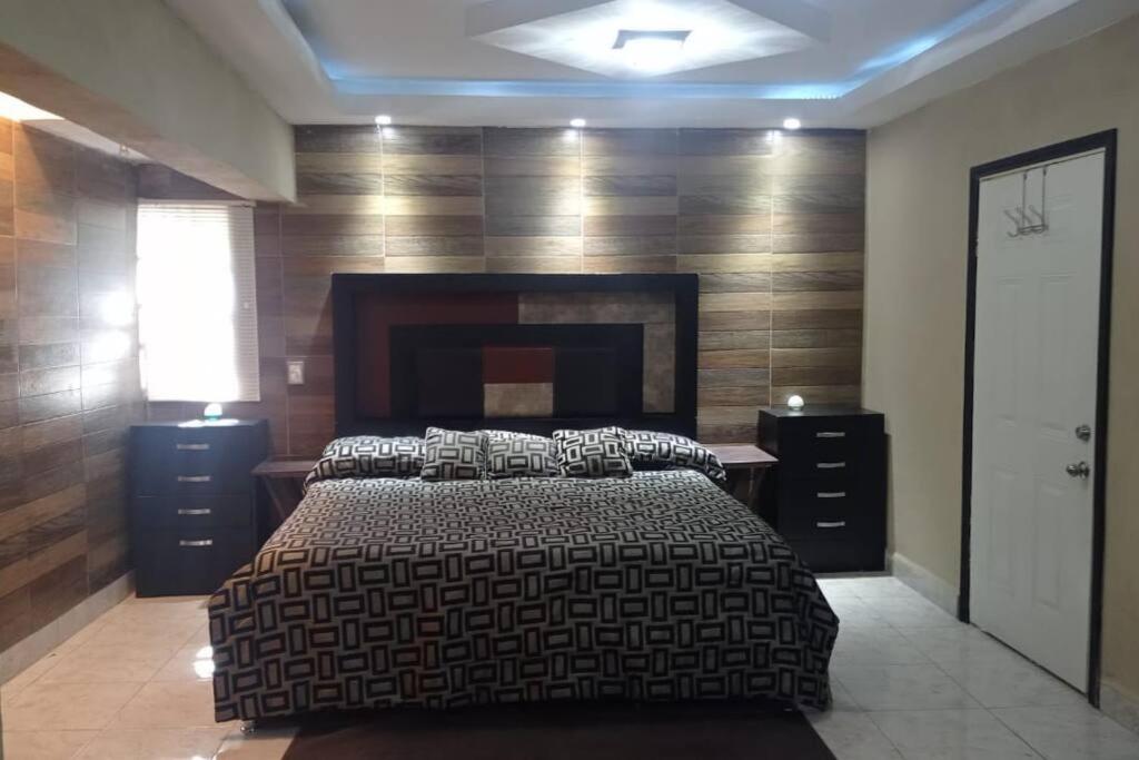 1 dormitorio con 1 cama grande y chimenea en Acogedor departamento en el centro de la ciudad, en Reynosa